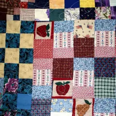 Kolorowy patchwork, czyli technika szycia z kawałków materiału, tworzy wzory z jabłkami, kwiatami i flagami USA.