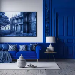 Salon w odcieniach **cobalt blue**. Błękitna sofa, ściany i drzwi tworzą monochromatyczną przestrzeń. Obraz przedstawia dwór w podobnej tonacji.