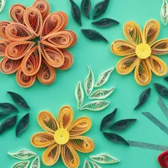 Kwiaty i liście wykonane techniką quilling. Wzory z papierowych pasków tworzą delikatne kompozycje.
