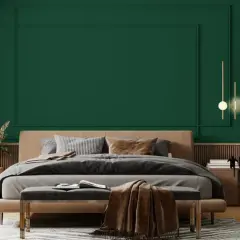 Sypialnia z łóżkiem i narzutą w odcieniu **midnight green**. Eleganckie lampy wiszące i drewniane meble tworzą przytulną atmosferę.