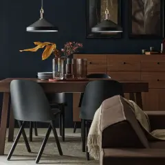 Elegancka jadalnia z drewnianym stołem i czarnymi krzesłami. W tle komoda z mosiądz lub brąz.