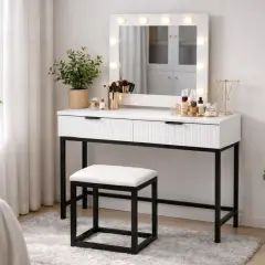Elegancka toaletka z podświetlanym lustrem, pełna kosmetyków i akcesoriów. Obok zielone rośliny i wygodny stołek.