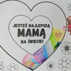 Dziecko koloruje serce z napisem "Jesteś najlepszą mamą na świecie!". Wokół serca znajdują się ornamenty do druku w kształcie kwiatów.