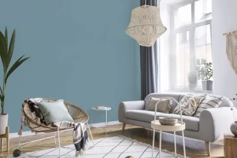 Przytulny salon z sofą i fotelem. Ściany w odcieniu **kolor błękit** tworzą spokojną atmosferę.