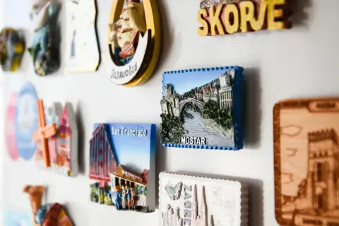 Kolekcja **dużych magnesów na lodówkę** z widokami Mostaru, San Francisco i innych miast.