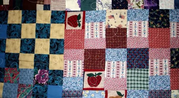 Kolorowy patchwork, czyli technika szycia z kawałków materiału, tworzy wzory z jabłkami, kwiatami i flagami USA.
