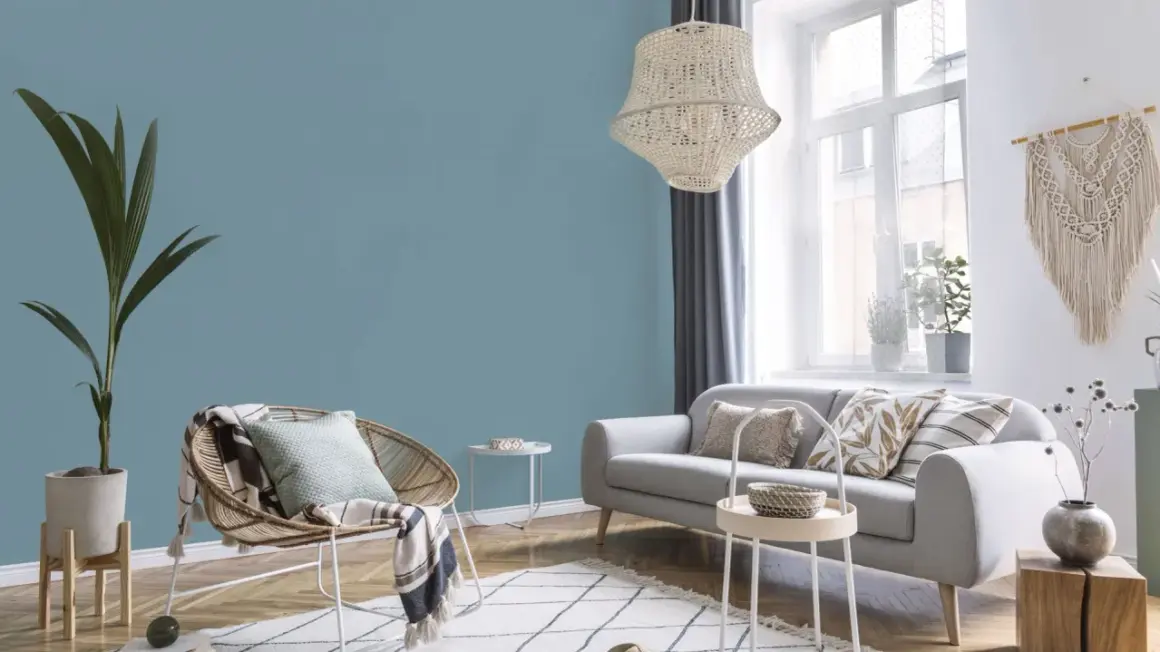 Przytulny salon z sofą i fotelem. Ściany w odcieniu **kolor błękit** tworzą spokojną atmosferę.