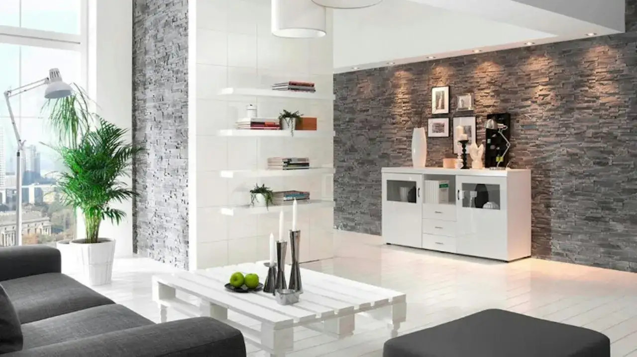 Nowoczesny salon z szarą ścianą z kamienia, białymi p&oacute;łkami i meblami.