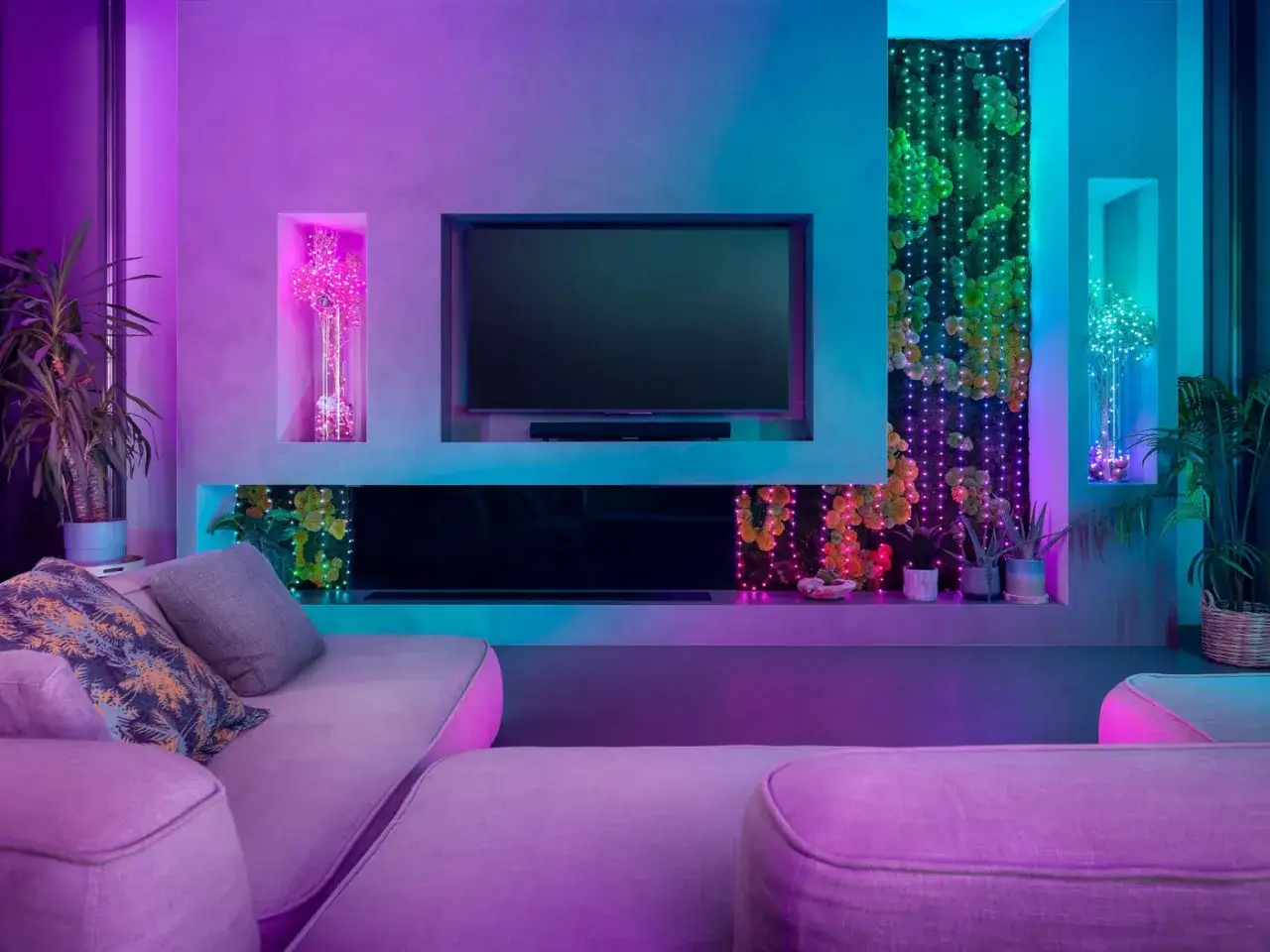 Nowoczesny salon z kanapą w fioletowym świetle, gdzie dekoracyjne lampki na druciku tworzą magiczną atmosferę wok&oacute;ł roślin i wnęk.