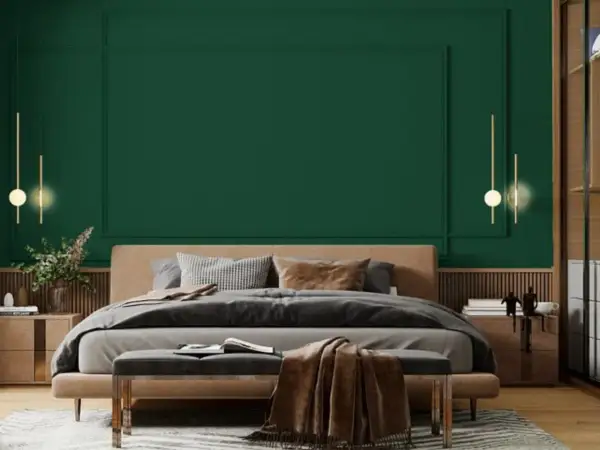 Sypialnia z łóżkiem i narzutą w odcieniu **midnight green**. Eleganckie lampy wiszące i drewniane meble tworzą przytulną atmosferę.